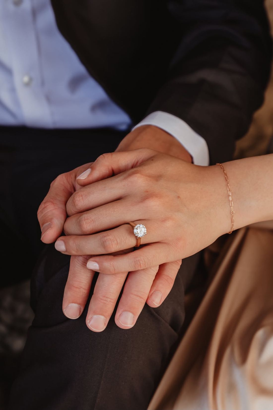 Yume and Christopher holding hands, her engagement ring in view